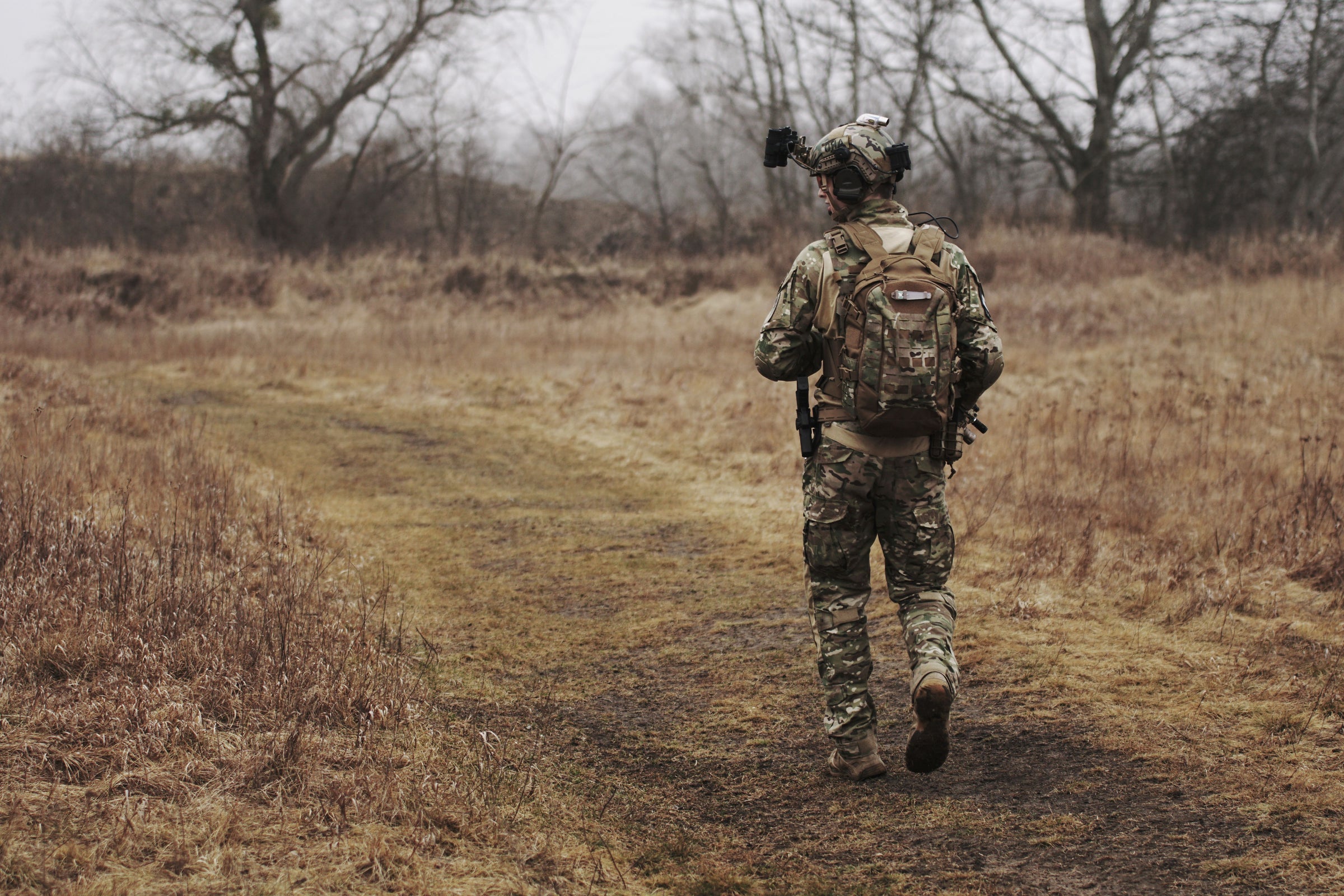 Service member walking through an open field